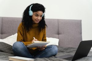 smiley teenage girl using laptop online school